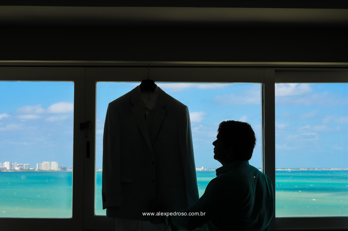 noivo olhando para o terno do ricardo almeida com o mar do caribe de fundo um no Dreams Sands Cancun Resort & Spa