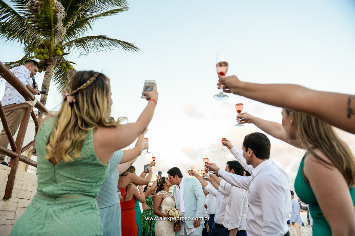 noivo se beijando no momento da saida no meio do corredor feito pelos padrinhos com taca de champgne nas maos 