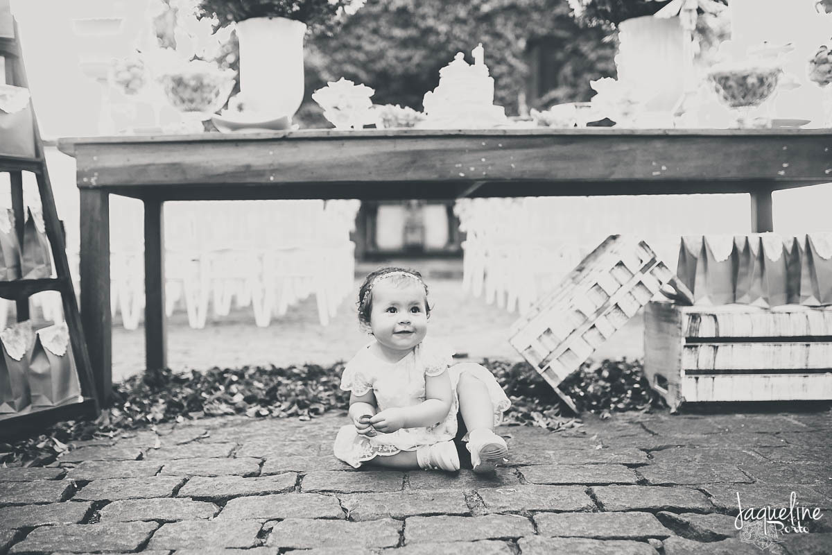 fotografia-de-batizado-de-menina-e-festa-de-um-ano-gruta-nossa-senhora-de-lourdes-tijuca-rio-de-janeiro-crianca-posando-para-a-foto-na-mesa-do-bolo