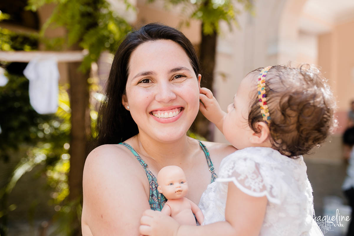 jaqueline-porto-fotografia-de-batizado-de-menina-e-festa-de-um-ano-gruta-nossa-senhora-de-lourdes-tijuca-rio-de-janeiro-mae-sorrindo-com-filha-no-colo