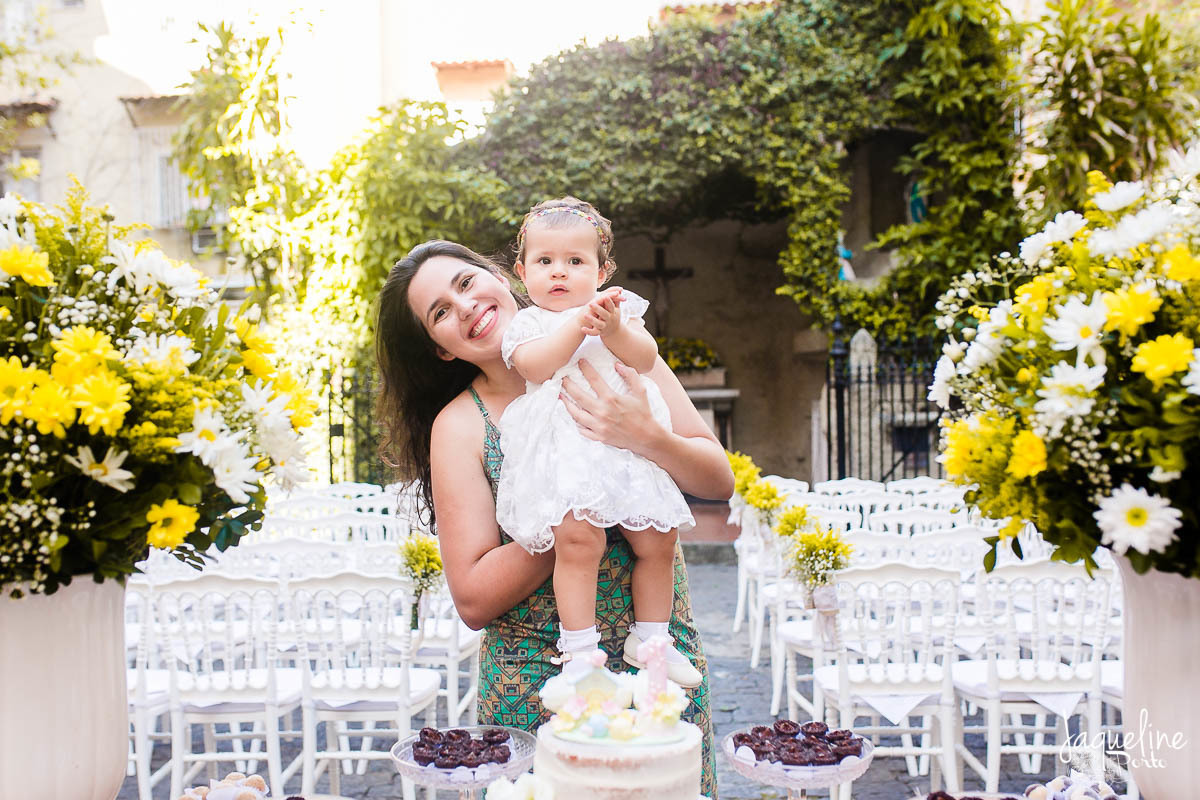 fotografia-de-batizado-de-menina-e-festa-de-um-ano-gruta-nossa-senhora-de-lourdes-tijuca-rio-de-janeiro-decoracao-em-tons-de-amarelo-mae-e-filha-na-mesa-do-bolo