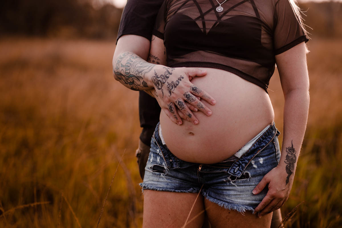Casal fazendo ensaio gestante na ilha do governador. Pai com a mão na barriga da esposa