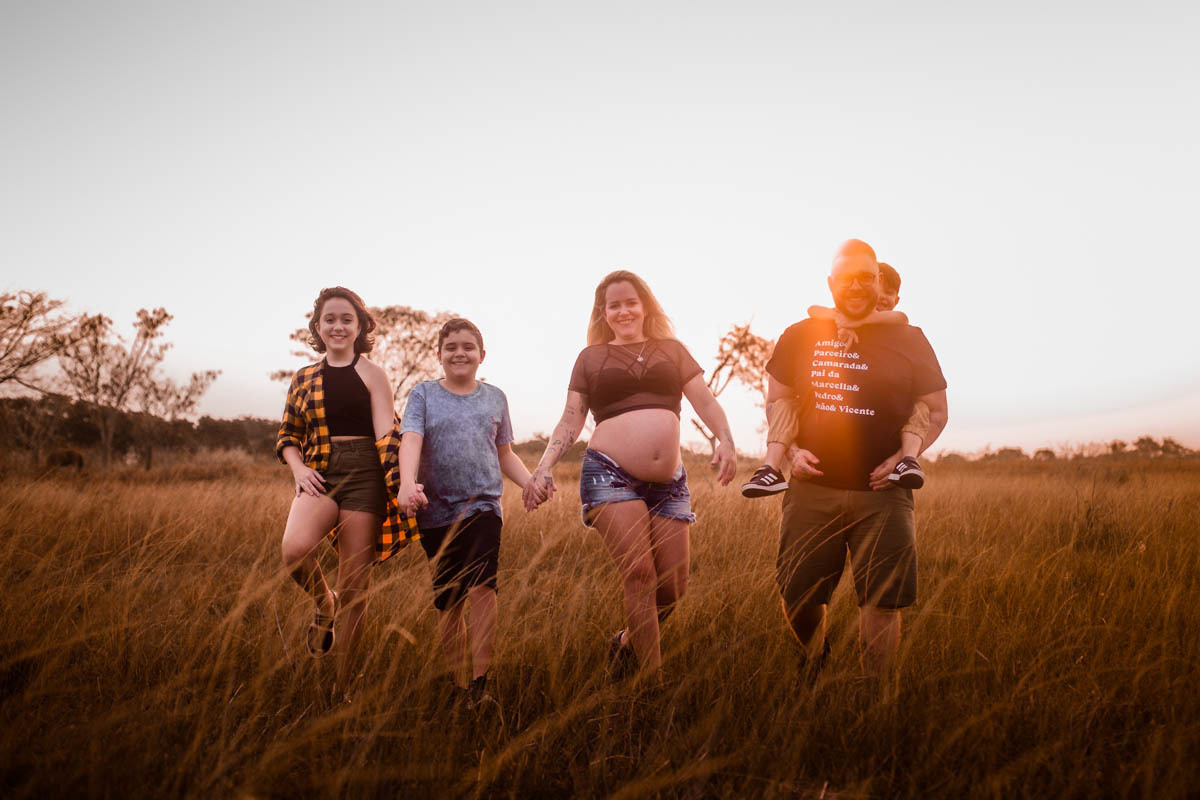 Gestante sendo fotografada com sua família em ensaio fotografico na ilha do governador