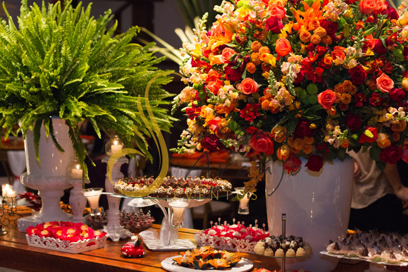 Casamento Zéfiro Niterói, mesa de convidados com flores laranja, vermelho e amarelo com velas.