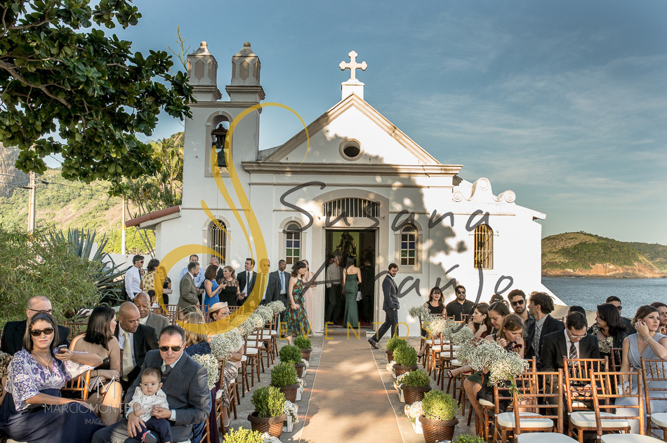 Casamento Zéfiro Niterói, Cerimônia na Fortaleza de Santa Cruz, Capela de Santa Bárbara com flores brancas. mesa de convidados com flores brancas.