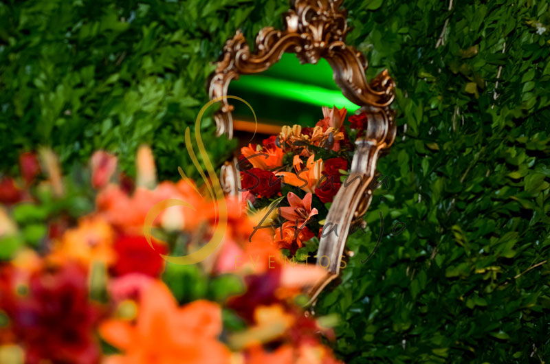 Casamento Zéfiro Niterói, mesa de doces e bolo com flores laranja e vermelho, paisagismo sob a mesa, muro inglês e espelhos.