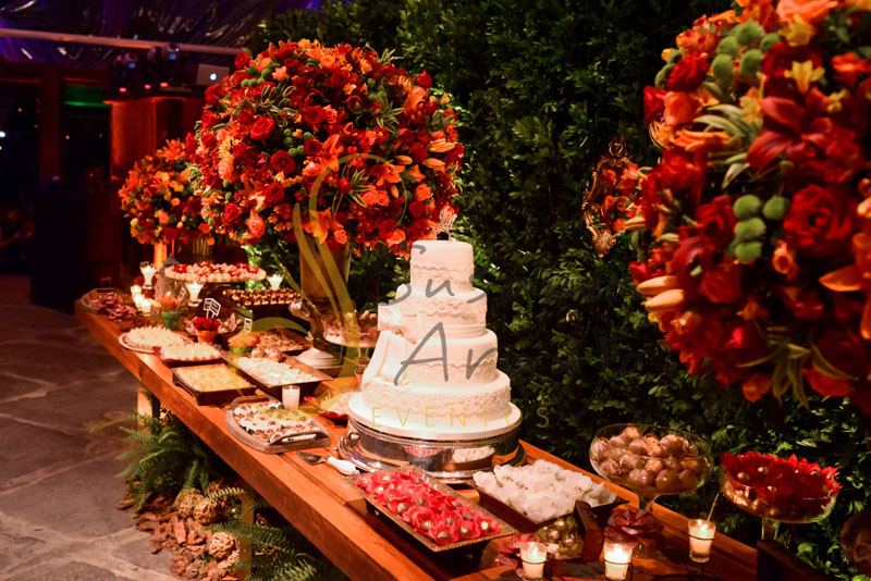 Casamento Zéfiro Niterói, mesa de doces  e bolo com flores aranja e vermelho.