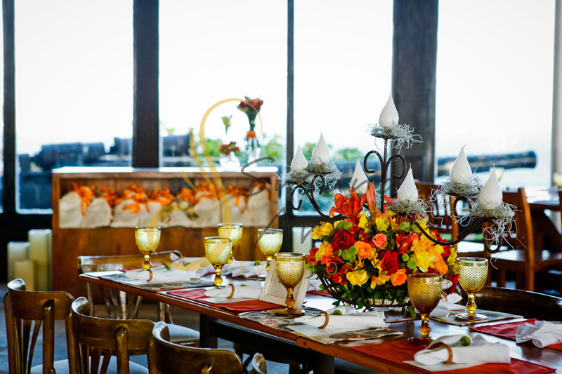 Casamento Zéfiro Niterói, mesa de convidados com flores laranja, vermelho e amarelo com velas.