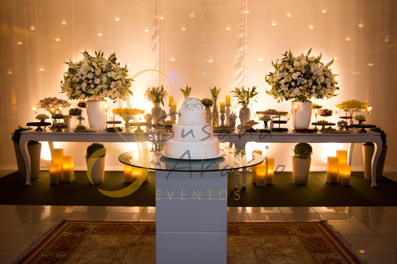 Decoração Casamento Tio Sam Niterói, mesa de doces e bolo com flores e arranjos de flores brancas.
