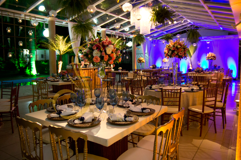 Decoração de casamento Solar Imperial, mesa de convidados de espelho com flores e arranjos de flores brancas, rosa e azuis. Composta com sousplat, guardanapos e taças