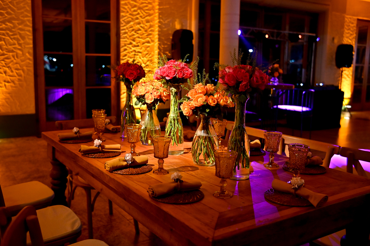 Aniversário de 40 anos - Rio Cricket - Mesas de convidados com flores em tons de laranja, rosa e marsala, móveis em madeira.