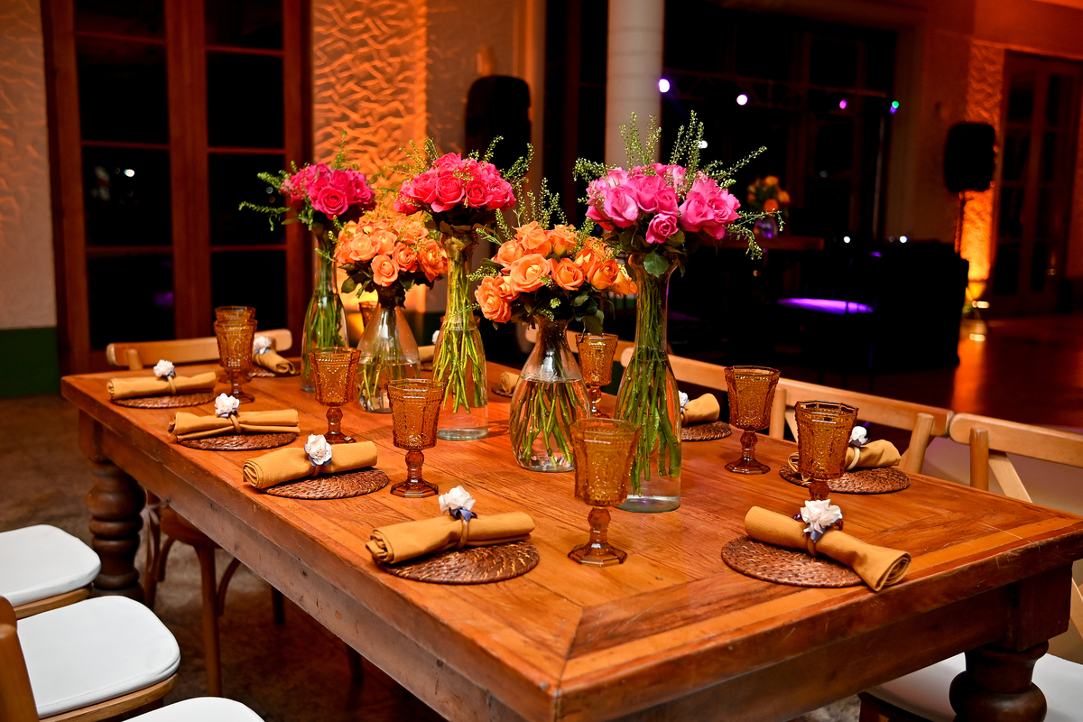 Aniversário de 40 anos - Rio Cricket - Mesas de convidados com flores em tons de laranja, rosa e marsala, móveis em madeira.
