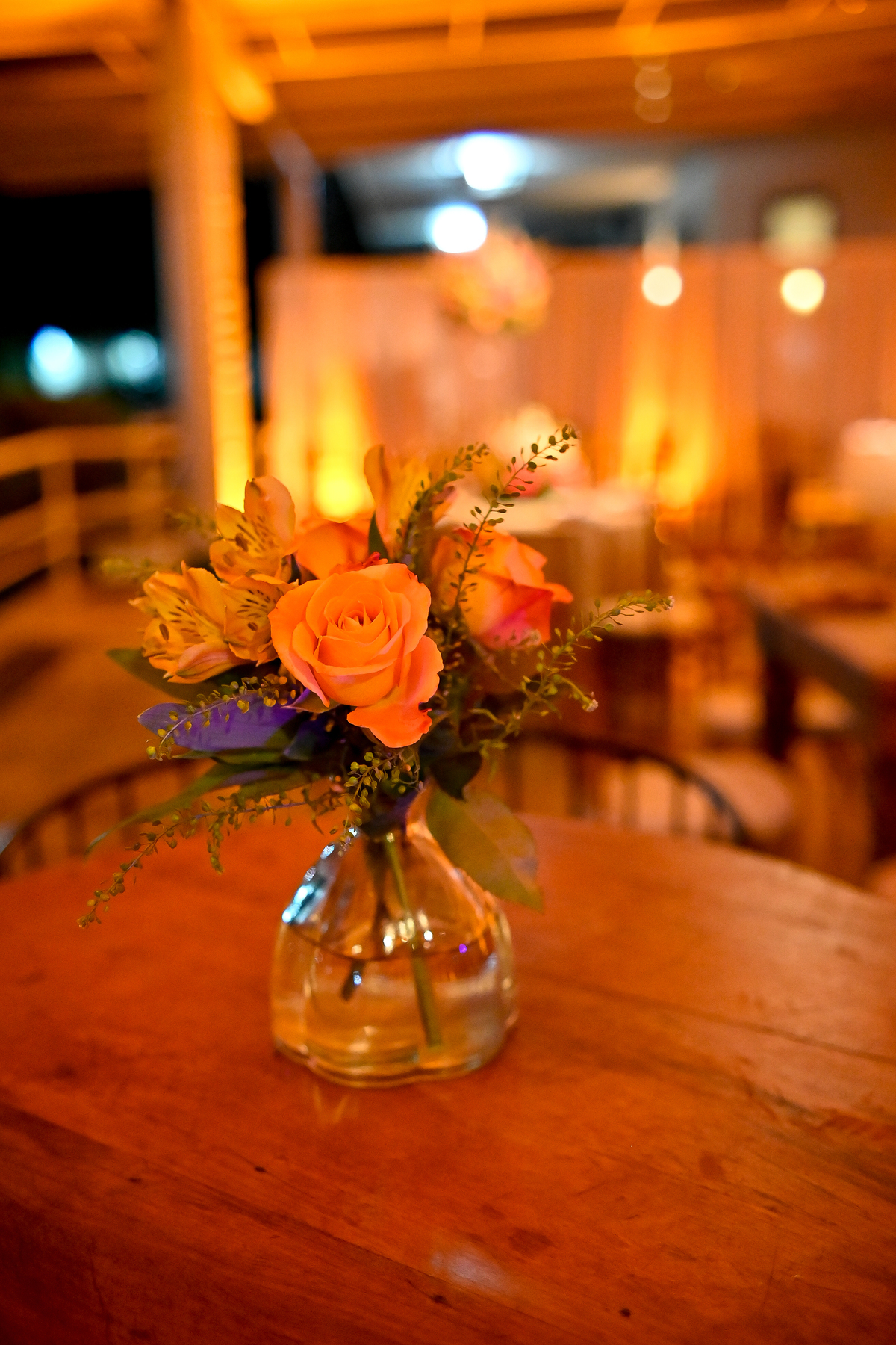 Aniversário de 40 anos - Rio Cricket - Mesas de convidados com flores em tons de laranja, rosa e marsala, móveis em madeira.