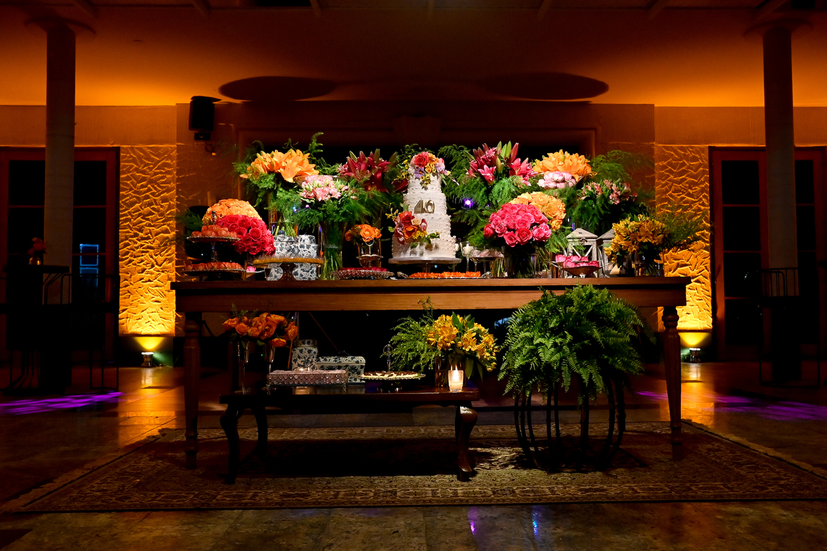 Aniversário de 40 anos - Rio Cricket - Mesa de bolo e doces com flores em tons de laranja, rosa e marsala.