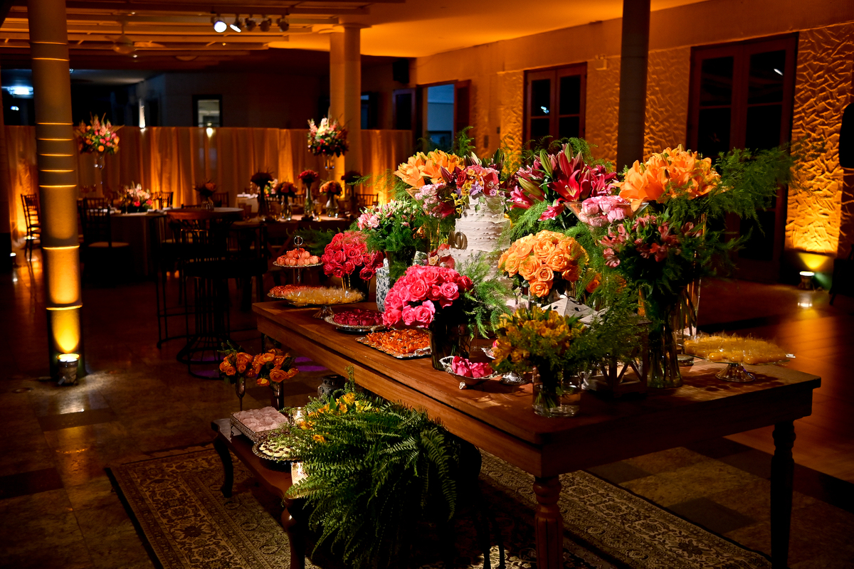 Aniversário de 40 anos - Rio Cricket - Mesa de bolo e doces com flores em tons de laranja, rosa e marsala.