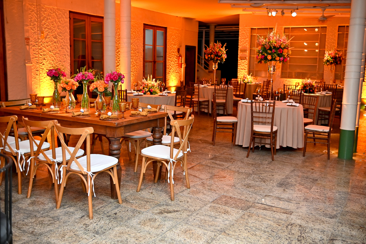 Aniversário de 40 anos - Rio Cricket - Mesas de convidados com flores em tons de laranja, rosa e marsala, móveis em madeira.