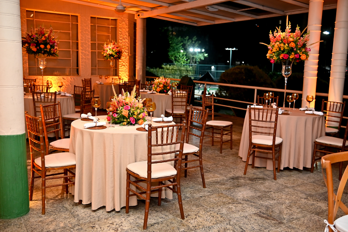 Aniversário de 40 anos - Rio Cricket - Mesas de convidados com flores em tons de laranja, rosa e marsala, móveis em madeira.