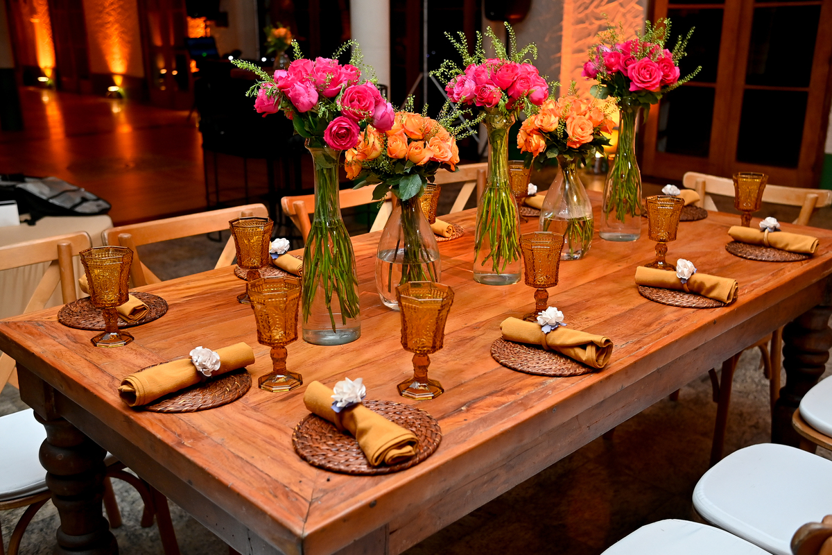 Aniversário de 40 anos - Rio Cricket - Mesas de convidados com flores em tons de laranja, rosa e marsala, móveis em madeira.