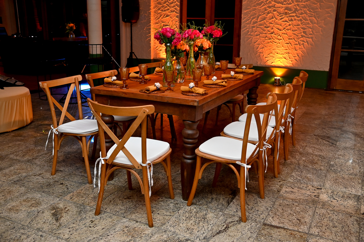 Aniversário de 40 anos - Rio Cricket - Mesas de convidados com flores em tons de laranja, rosa e marsala, móveis em madeira.