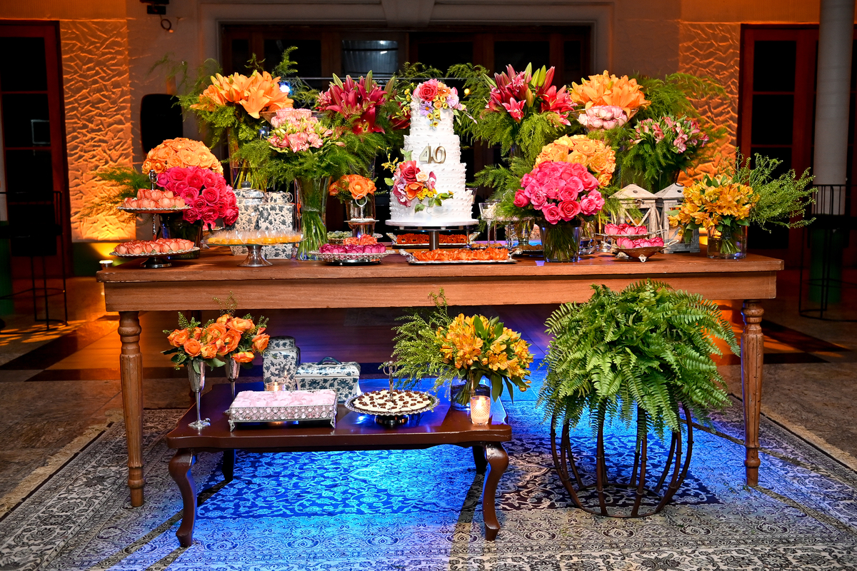 Aniversário de 40 anos - Rio Cricket - Mesa de bolo e doces com flores em tons de laranja, rosa e marsala.