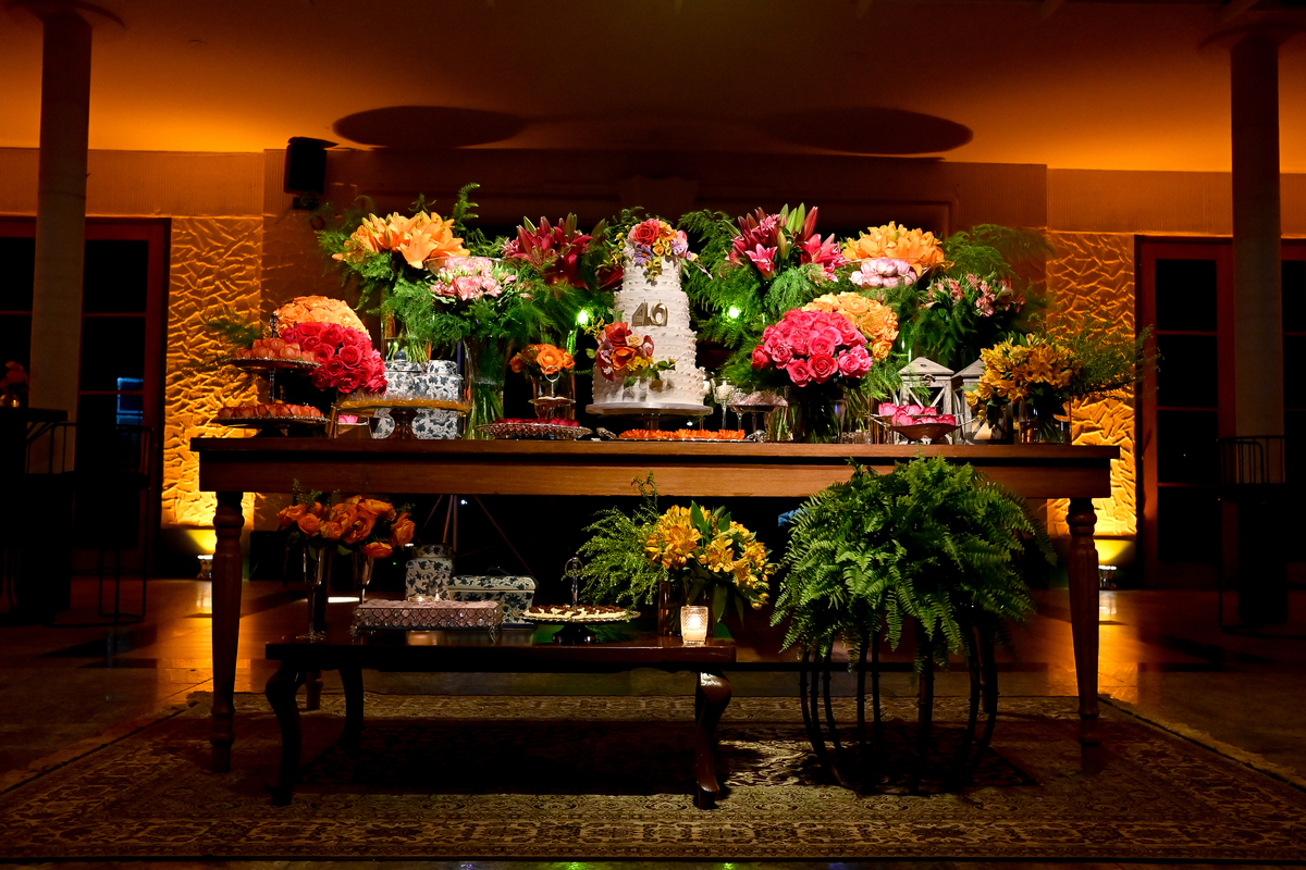Aniversário de 40 anos - Rio Cricket - Mesa de bolo e doces com flores em tons de laranja, rosa e marsala.