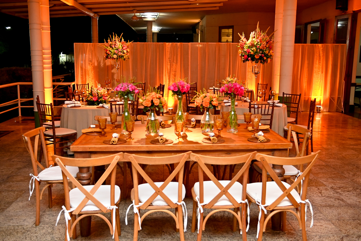 Aniversário de 40 anos - Rio Cricket - Mesas de convidados com flores em tons de laranja, rosa e marsala, móveis em madeira.