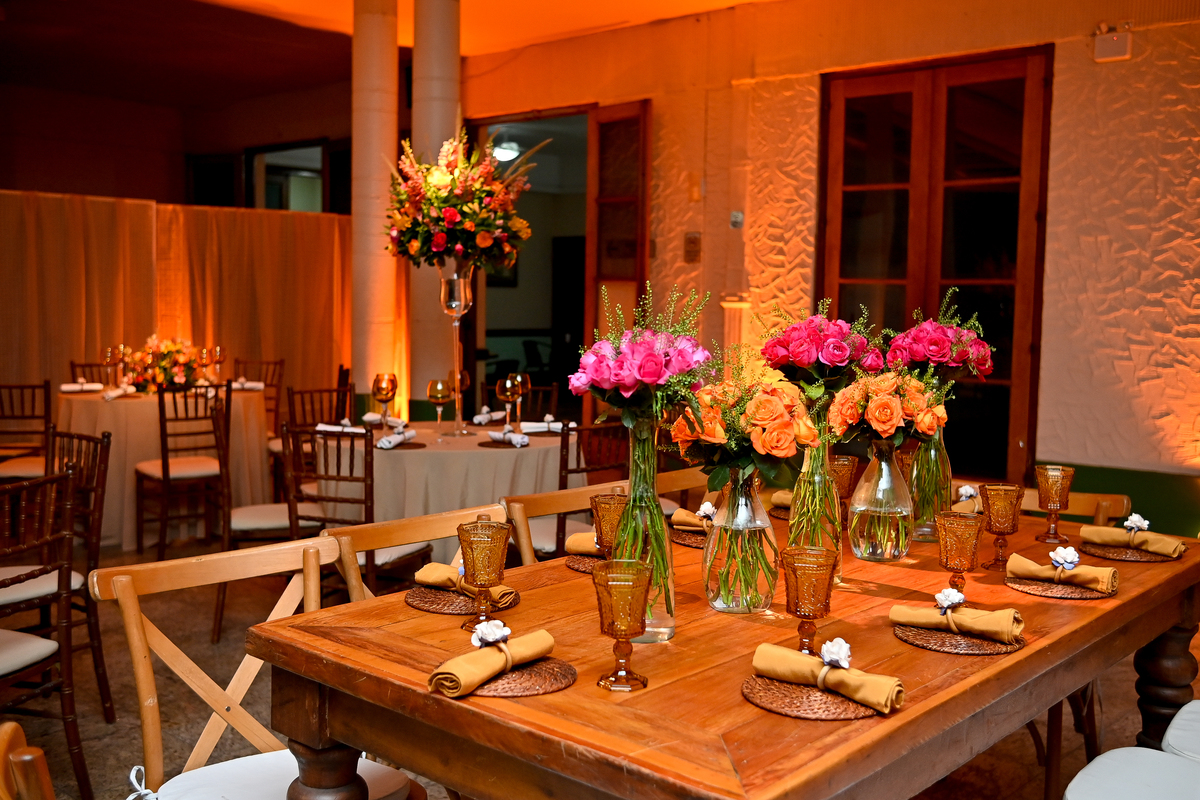 Aniversário de 40 anos - Rio Cricket - Mesas de convidados com flores em tons de laranja, rosa e marsala, móveis em madeira.