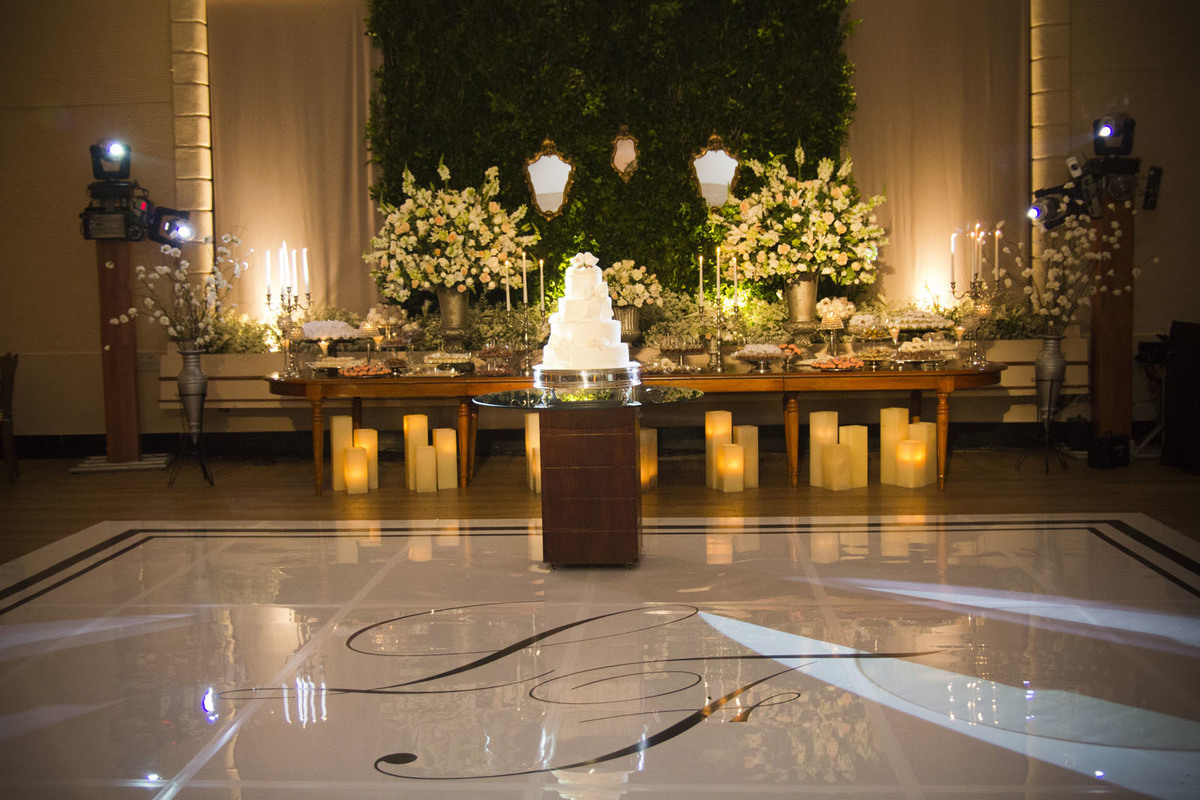 Casamento Rio Cricket Niterói, mesa de doces e bolo com flores e arranjos de flores brancas, e mobiliário de madeira.  Velas, 
