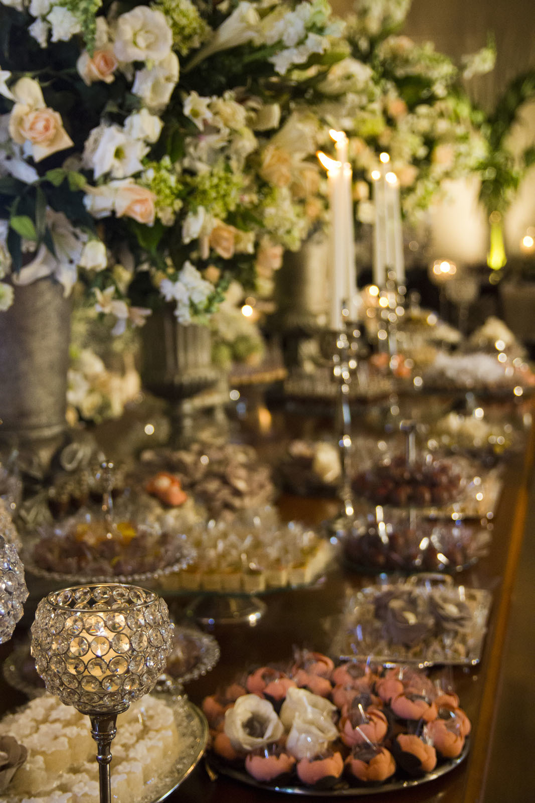 Casamento Rio Cricket Niterói, mesa de doces e bolo com flores e arranjos de flores brancas, e mobiliário de madeira.  Velas, 