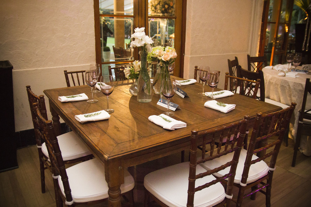 Casamento no Rio Cricket - Mesas de convidados com flores brancas, velas e móveis em madeira clássica.
