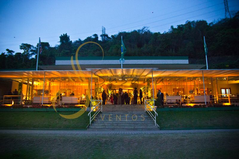 Casamento Rio Cricket Niterói, lounges com flores e arranjos de flores brancas, e mobiliário de madeira.