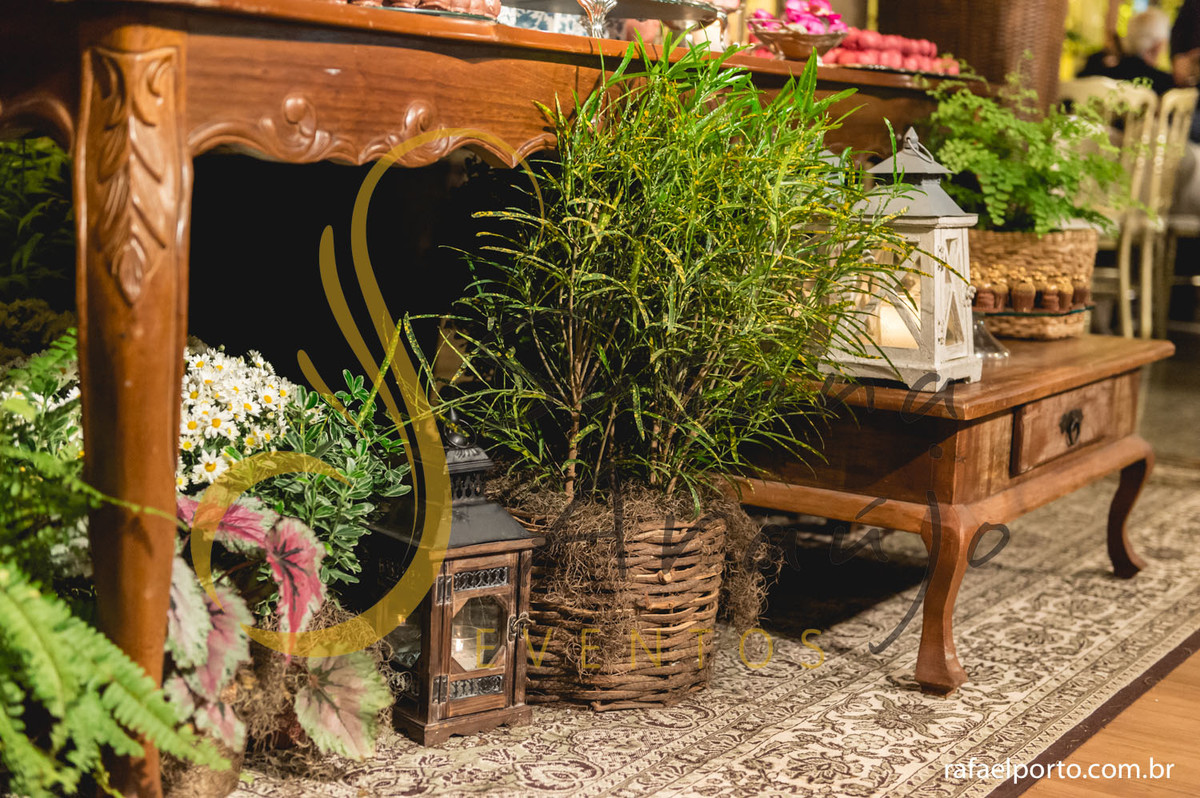 mesa de doces e bolo com flores e arranjos de flores rosa, laranja, brancas, e mobiliário de madeira. 
