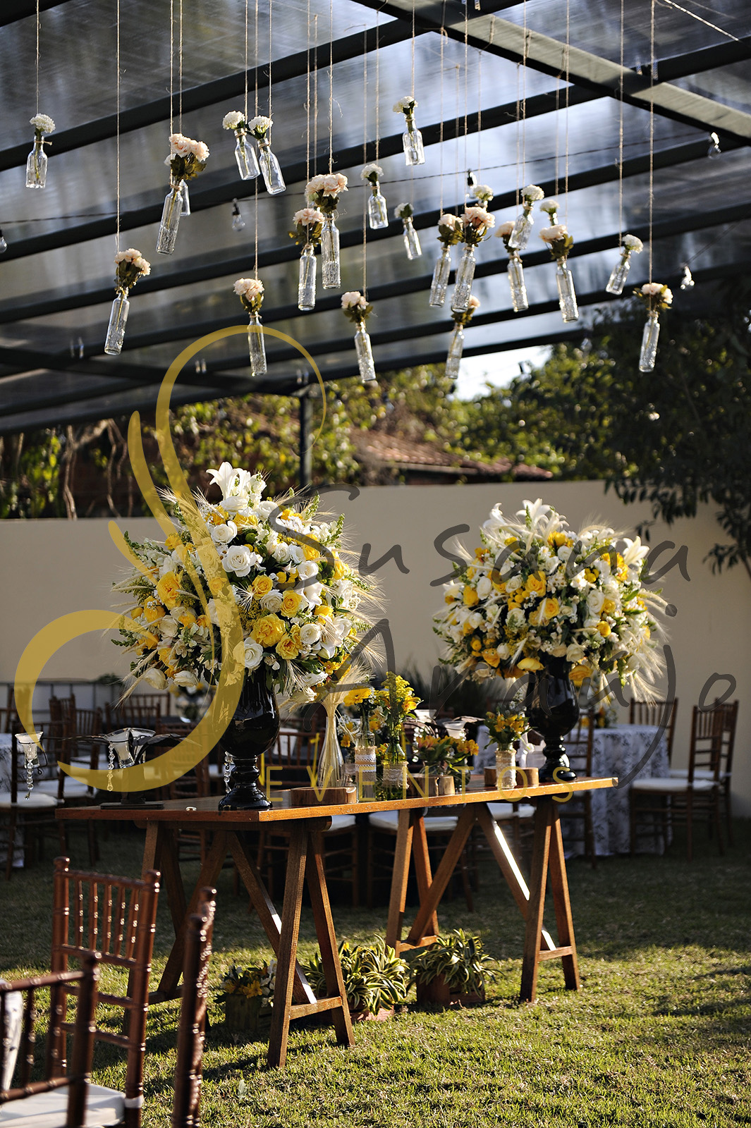 Casamento Cerimônia ao ar livre gramado sitio Decoração floral flores amarelas brancas mesa doces bolo arranjo alto decorativo flores suspensas vidrinhos