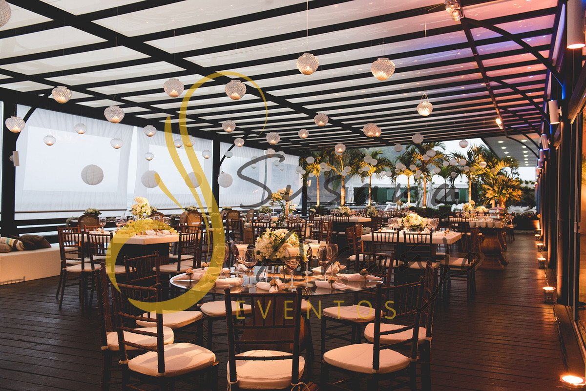 Casamento Clube Aquidaba Angra Decoração floral flores brancas mesa convidados centro composição flores brancas mesa redonda vidro varanda velas suspensas bico de jaca