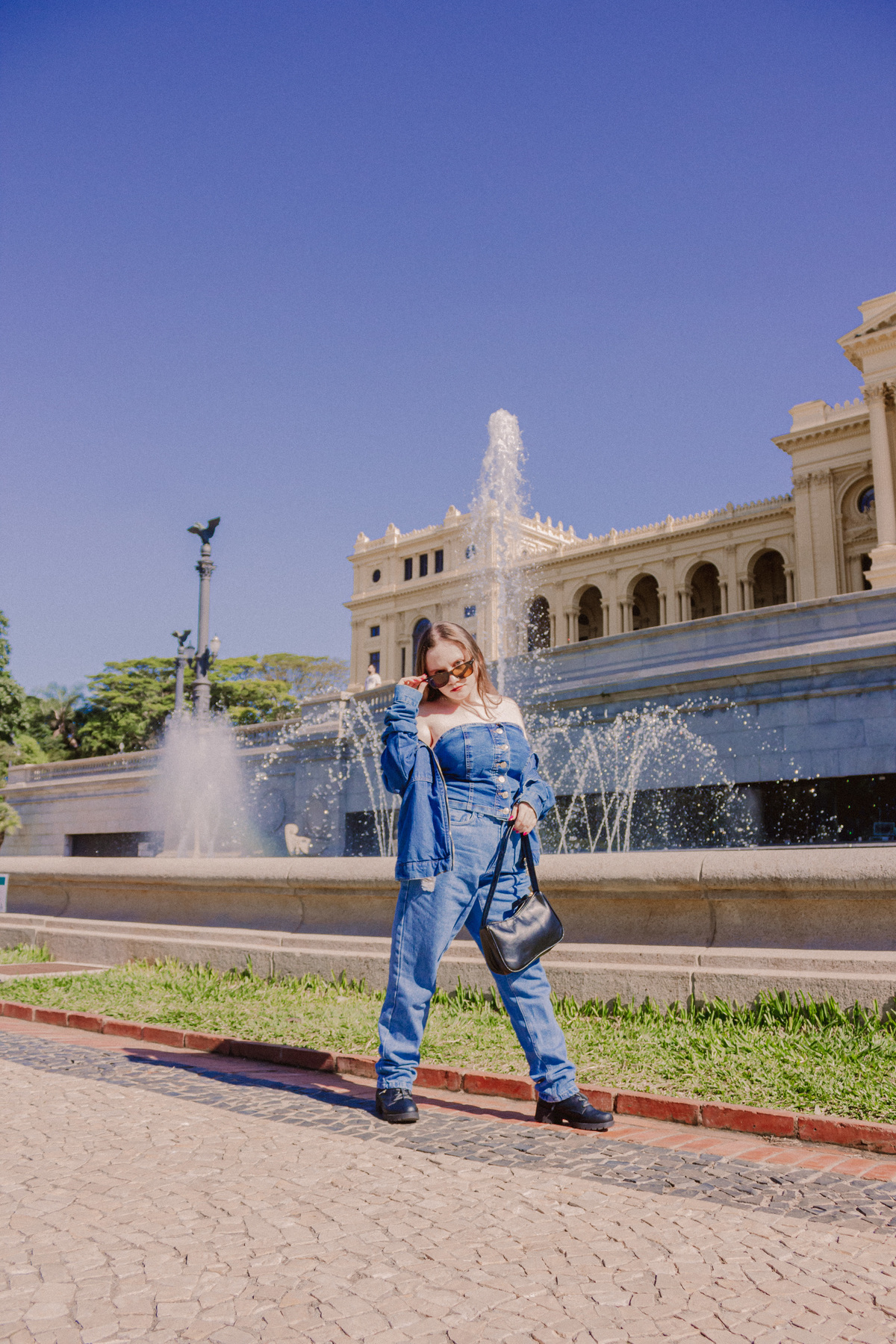 menina olhando de óculos escuro com roupa jeans, ensaio realizado no museu do ipiranga