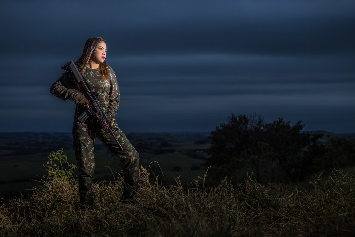 Brenda segurando arma de air soft  em sessão fotográfica no alto da serra em Piracicaba S.P.