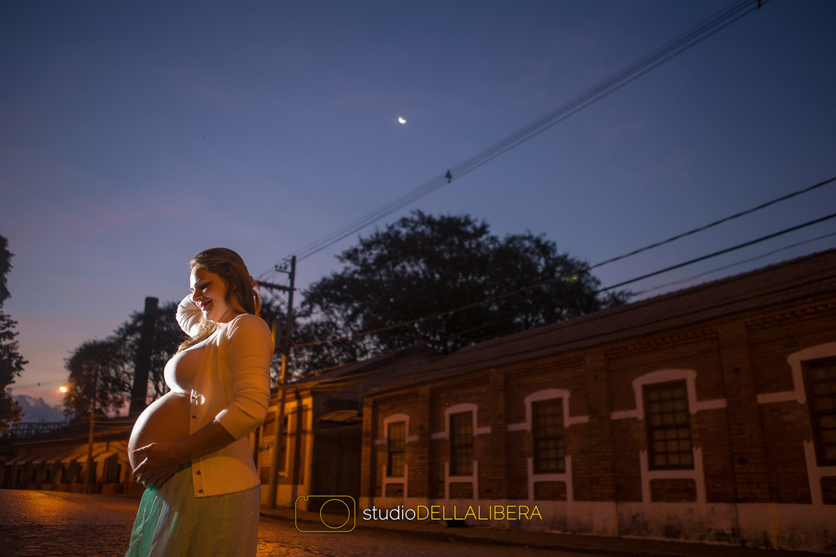 Mamãe Cristiane na sessão fotográfica segurando a linda barriga em final de tarde com céu azul em Piracicaba S.P.