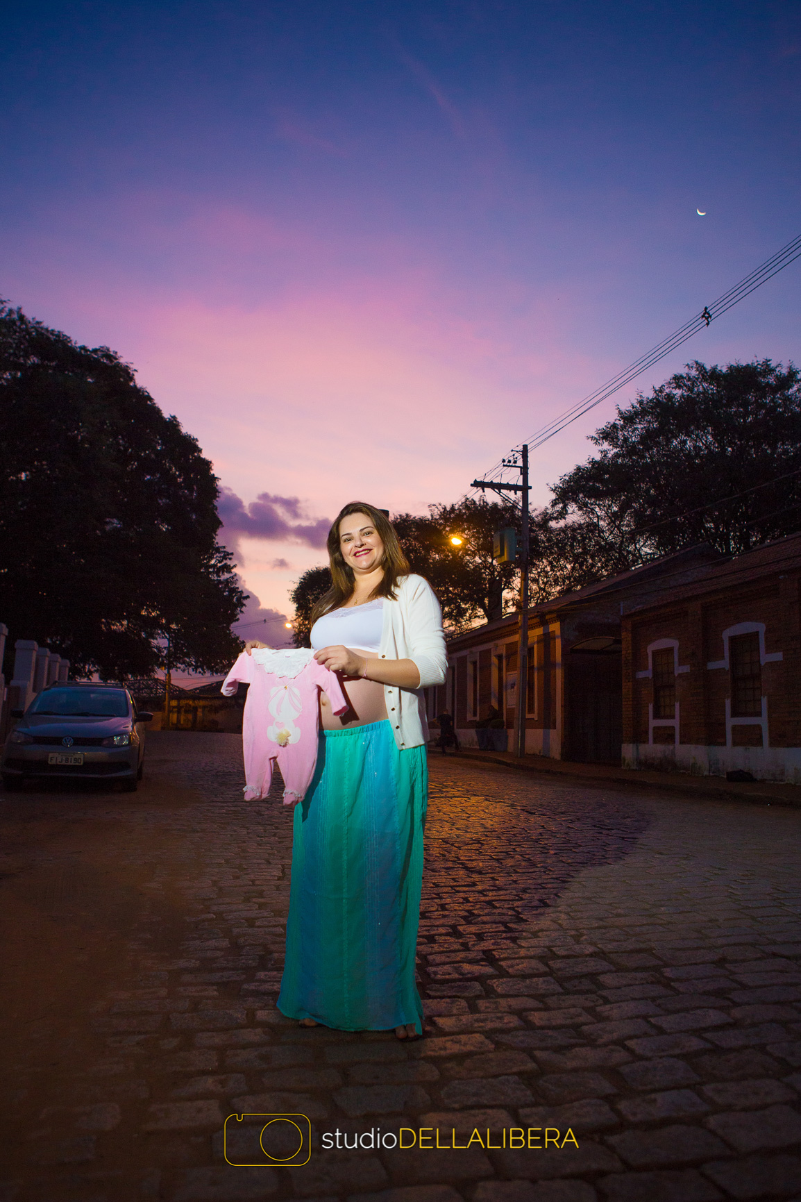 Mamãe segurando boneca para sessão fotográfica da gestação na rua de paralepípido em Piracicaba S.P.
