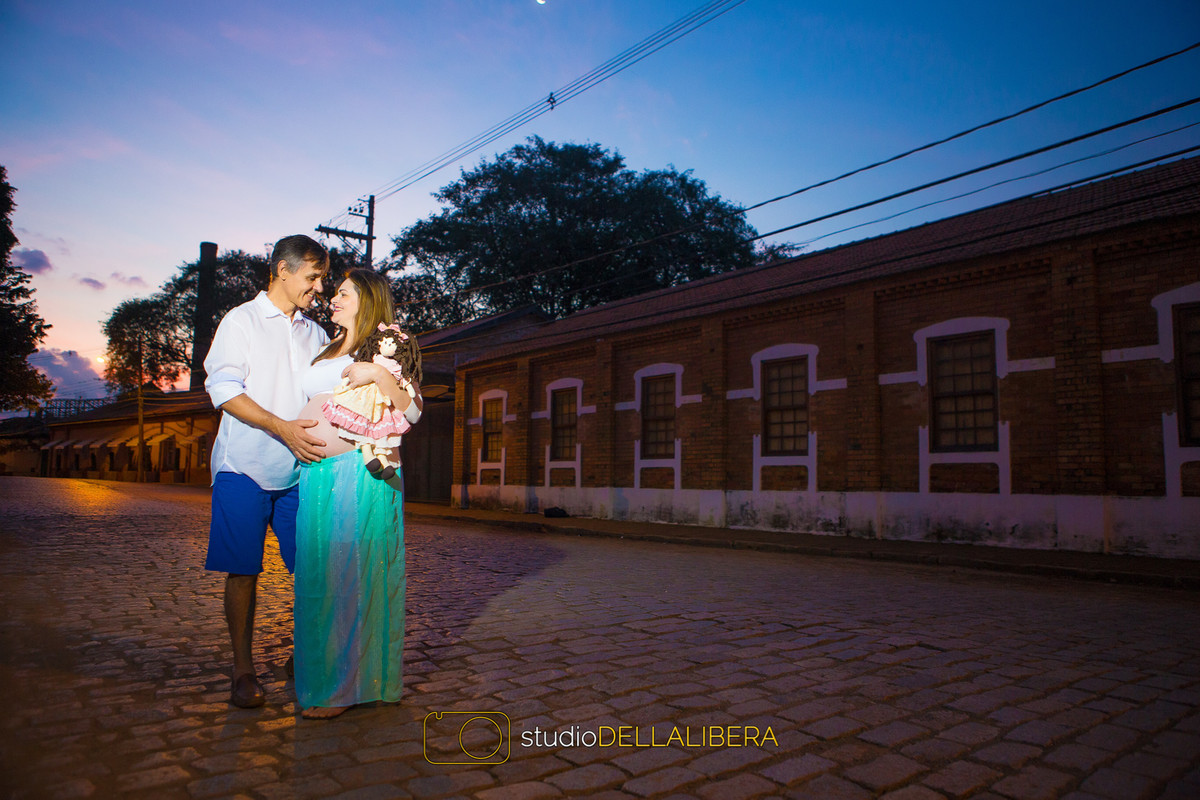 Casal no por do sol fazendo sessão fotográfica de gestante com fotografo Wilson pegando um lindo céu azul