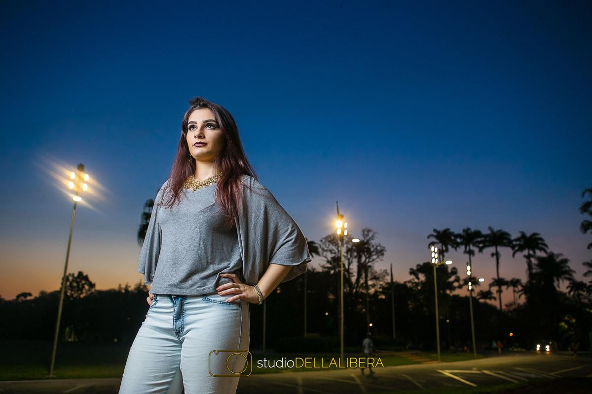 Alanis com as mãos na cintura modelando no cair da tarde com lindo céu azul em frente ao prédio central da Esalq em Piracicaba SP