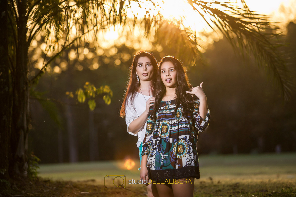 Alanis e Laura fazendo caretas na sessão fotográfica de família feita em meio a natureza com muito verde na Esalq no interior de São Paulo