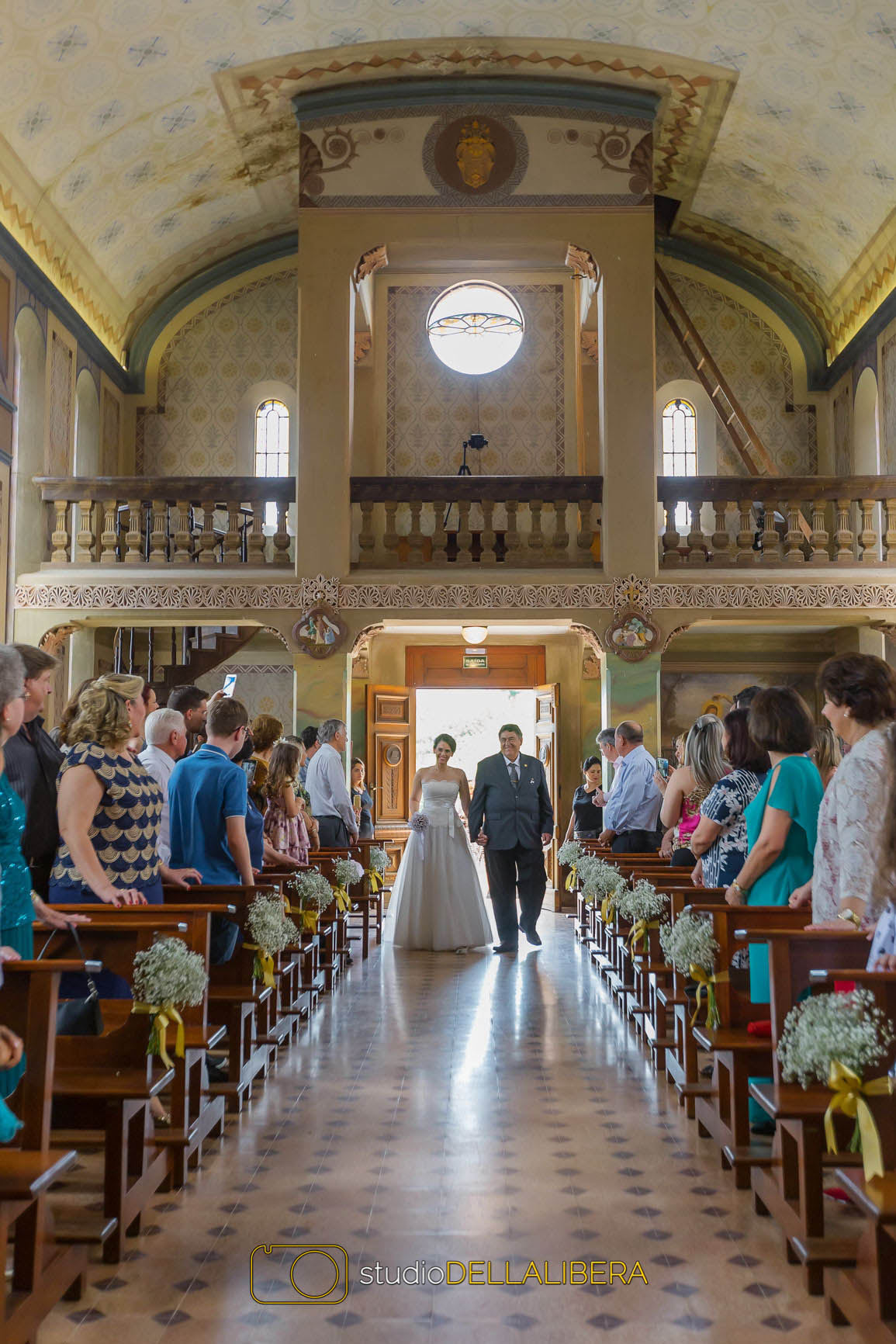Noiva Pricila entrando na igreja do monte alegre em Piracicaba com corredor decorado com mosquitinhos( egipsofila)