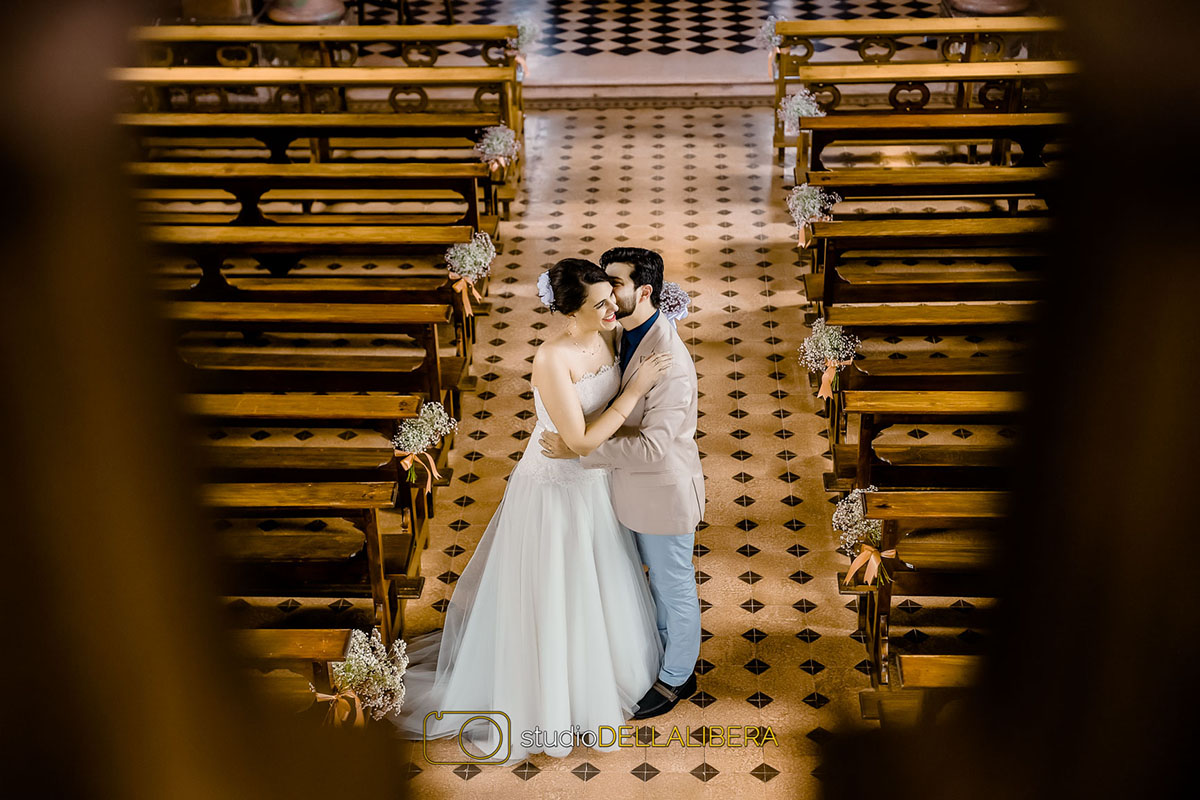 Beijo dos noivos no corredor da Igreja Monte Alegre na sessão fotografica feita pelo fotografo de casamento em Piracicaba SP