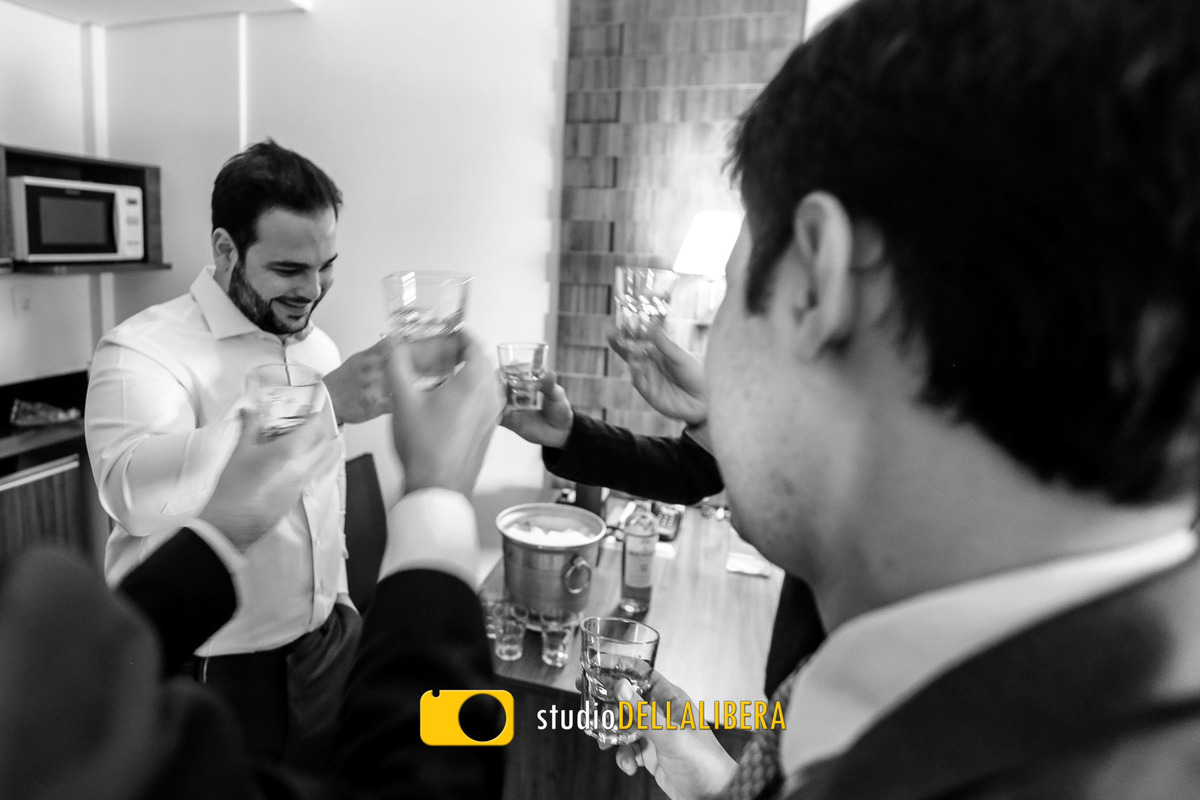 Noivo brindando com os amigos no quarto do hotel arco  em Piracicaba fot em PB