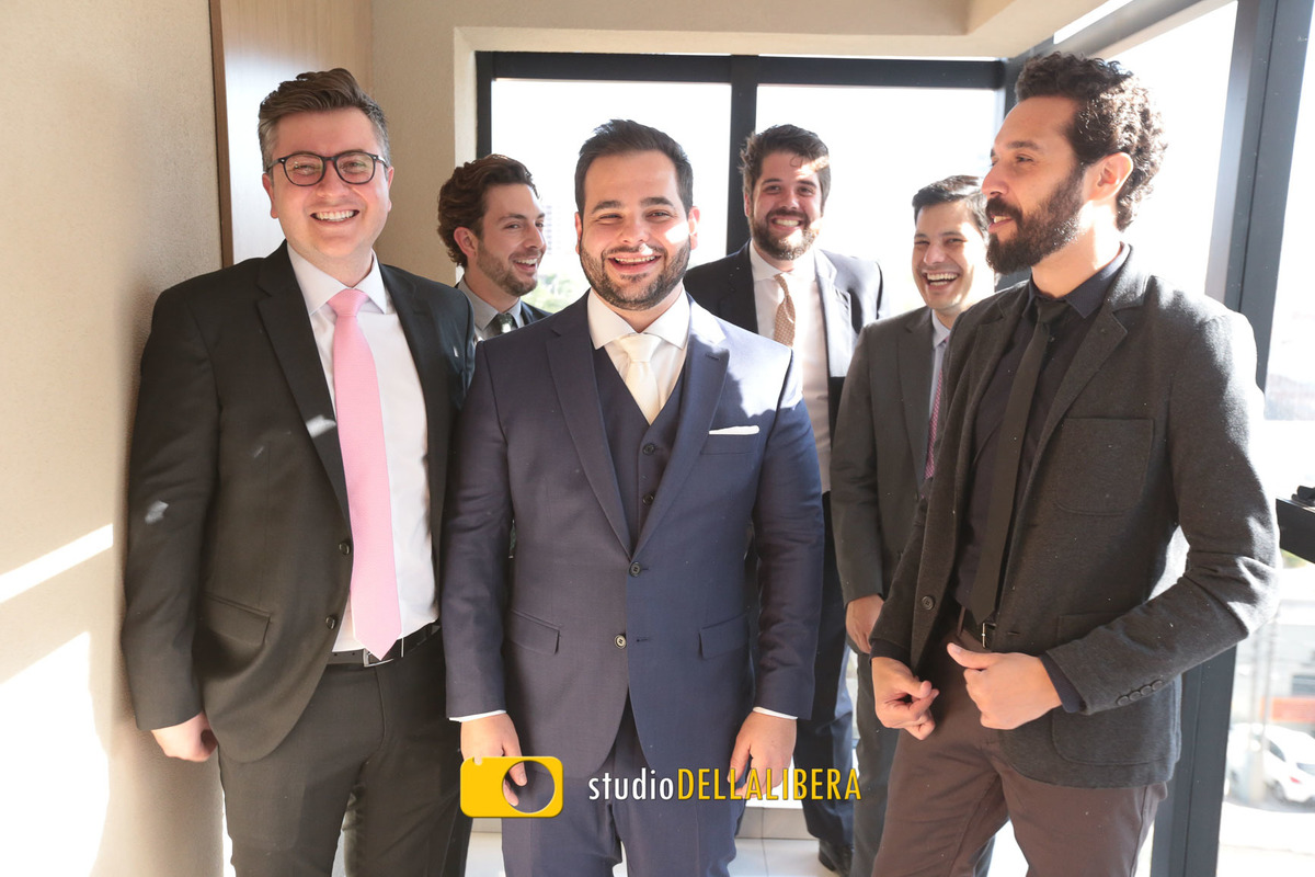 Noivo vestindo terno azul da Ricardo Almeida com os padrinhos ao fundo no hotel Arcor em Piracicaba SP