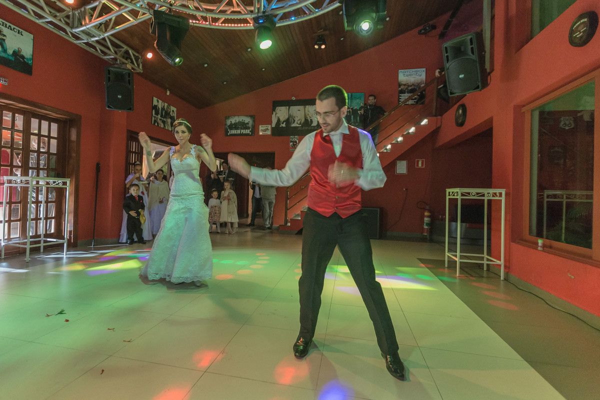 Noivo dançando sozinho e noiva atrás curtindo