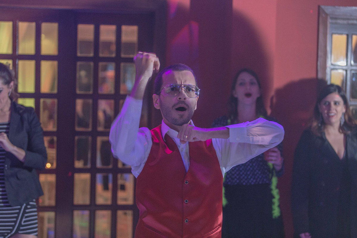 Noivo na pista de dança e convidados ao fundo