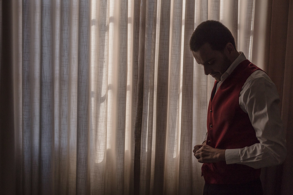 Noivo fechando seu colete em seu making of