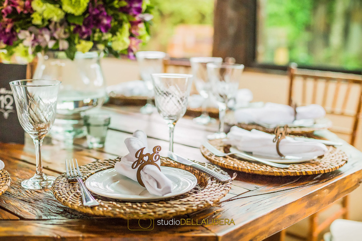 Detalhe do prato e do soupla com garfo e faca, na mesa de madeira, no salão Madero eventos