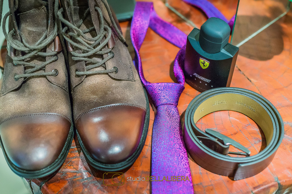 Noivo resolveu usar bota marrom para o dia do casamento, com gravata roxa cheia de detalhes, com cinto marrom combinando com a bota e perfume ferrari